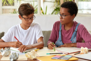 étudiante donne des cours particulier à un élève de primaire